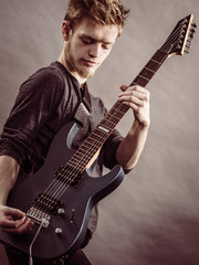 Obraz premium Young man playing electric guitar