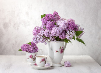 Retro still life with bouquet of Lilac and cup of tee.
