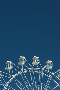 Ferris wheel against the blue sky. Season Holiday Entertainment Concept