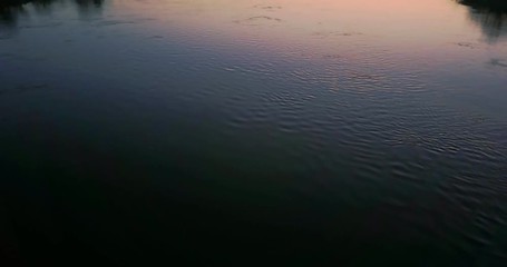 beautiful flight over the bridge and river at sunset. a girl stands on the bridge looking at the river. landscape