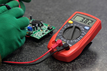 Repair of electrical and digital equipment, in the hands of a probe to check the voltage