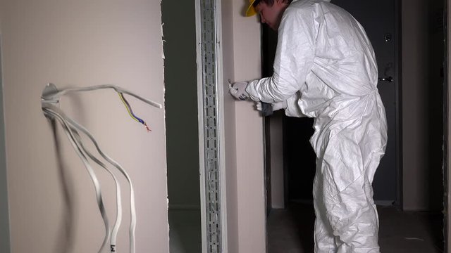 Electrician screw light switch with electrical drill. Man in work wear