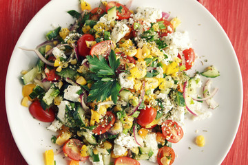 Colorful vegetable mix. Simple low calories salad. Cherry tomatoes, sweet corn, cucumber, bell pepper and cottage cheese. Weight loss dish. European cuisine. Top view.