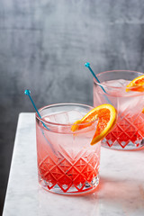Two Blood Orange Gin and Tonic Cocktails in Glasses on Marble Bar Top	