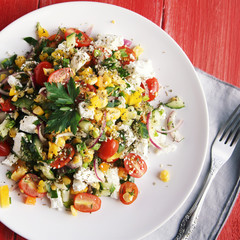 Colorful vegetable mix. Simple low calories salad. Cherry tomatoes, sweet corn, cucumber, bell pepper and cottage cheese. Weight loss dish. European cuisine. Top view. Toned photo.