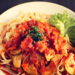 Ribbon pasta with Arrabiata sauce. Close up. Mediterranean dish. Tagliolini pasta with vegetables. Cauliflower, courgette and tomato stew. Italian cuisine. Vegan and vegetarian. Toned photo.