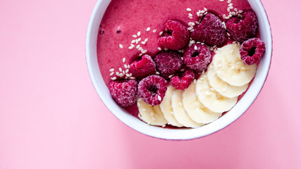 smoothie bowl frozen raspberry and banana, healthy nutrition, pink background