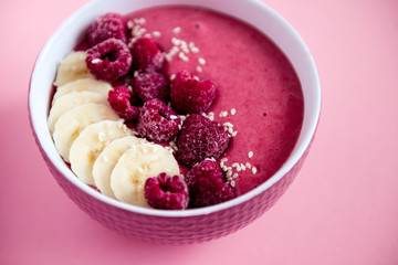 smoothie bowl frozen raspberry and banana, healthy nutrition, pink background