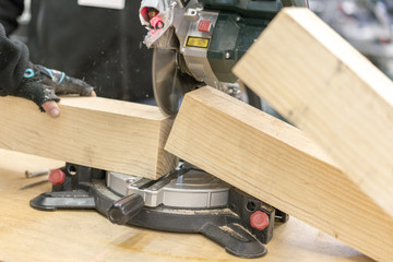 man carpenter cutting wood using table saw at construction site