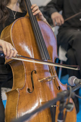 Detail of a woman playing a cello. Close up of cello with bow in hands
