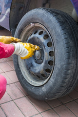 Repair and change car tire at auto service garage, mechanic changing wheel on car