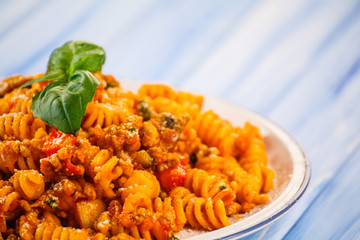 Pasta with tomato sauce on wooden table