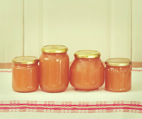 Homemade apple sauce in glass jars on vintage kitchen linen