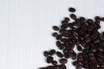 Roasted coffee beans on white wood table. coffee background with copy space.