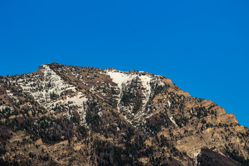 Clear sky above the snow-capped peak of a mountain