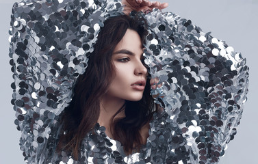 Sensual beautiful brunette woman in a shiny fashion dress of sequins