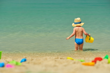 Two year old toddler playing on beach