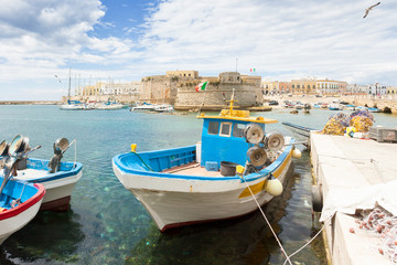 Obraz premium Gallipoli, Apulia - Fishing boat at the seaport in front of the town wall