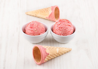 strawberry ice cream with bowl on wooden background