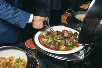 Catering buffet food indoor in luxury restaurant with meat colorful fruits and vegetables. People at a banquet taking different food. Colleagues Buffet Party Brunch Dinning Concept