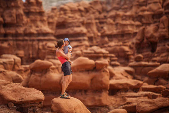 A mother and her baby son visit Goblin valley state park in Utah, USA