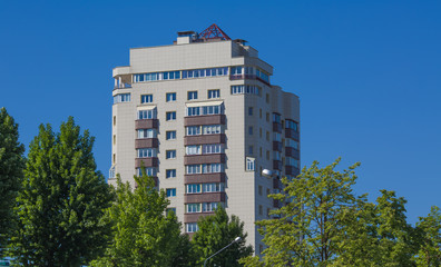 The multystoried building with the trees growing around