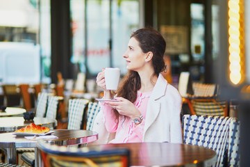 Woman drinking coffee in outdoor cafe or restaurant, Paris, France