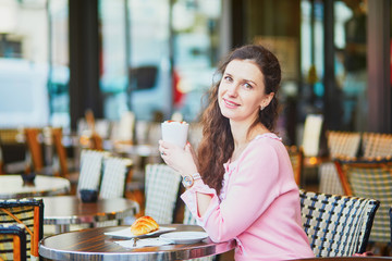 Woman drinking coffee in outdoor cafe or restaurant, Paris, France