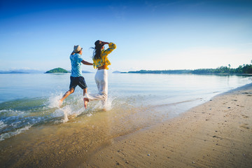 Happy middle aged couple running on a beach, Koh Mak Thailand