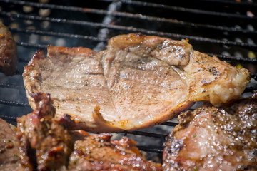 Barbecue lunch. Grilled meat chops in a black cast iron pan, close-up