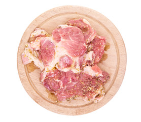 Slieced raw pork neck on wooden cutting board. Top view isolated on white background.
