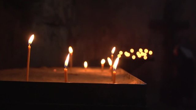 Lighting candles in a church. Religion, faith and sacred place concept.