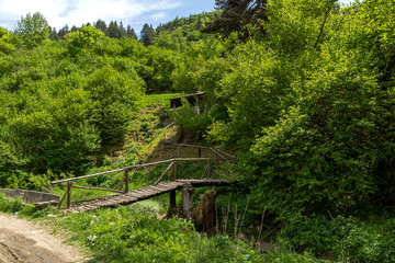Fototapeta na wymiar Wooden bridge over Fotinovo River near village of Fotinovo in Rhodopes Mountain, Pazardzhik region, Bulgaria