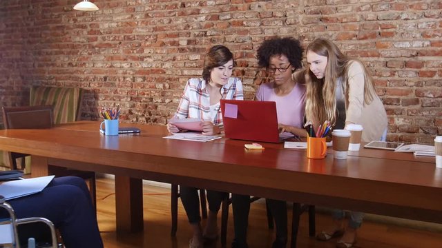 Young females planning at coworking space with disabled man in wheel chair