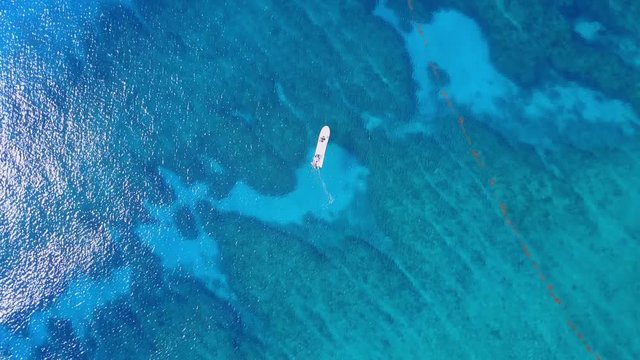 Aerial drone shot. View from above of the boat with divers in the distance from a bird's eye view. Turquoise water view coral coast of the Caribbean Sea. Riviera Maya Mexico.