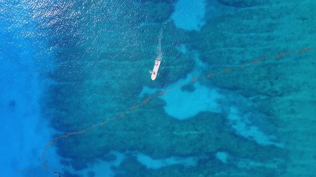 Aerial drone shot. View from above of the boat with divers in the distance from a bird's eye view. Turquoise water view coral coast of the Caribbean Sea. Riviera Maya Mexico.
