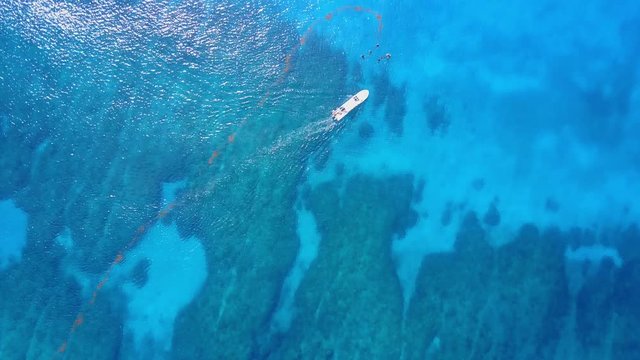 Aerial drone shot. View from above of the boat with divers in the distance from a bird's eye view. Turquoise water view coral coast of the Caribbean Sea. Riviera Maya Mexico.