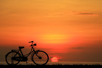 Naklejka na ściany i meble silhouette vintage bike on sunrise.