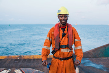 Seaman AB or Bosun on deck of offshore vessel or ship , wearing PPE personal protective equipment -...