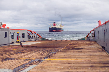 Anchor-handling Tug Supply AHTS vessel during dynamic positioning DP operations near FPSO tanker....