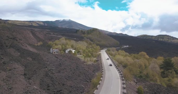Aerial view of road to Mount Etna or Mongibello Mungibeddu is active stratovolcano on the east coast of Sicily Italy in the Metropolitan City of Catania showing black vulcano landscape