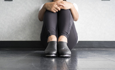 Tap dancer sitting down and holding her legs