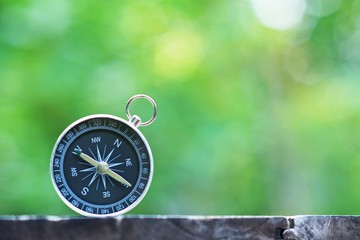 Compass with blur green background, journey planning concept