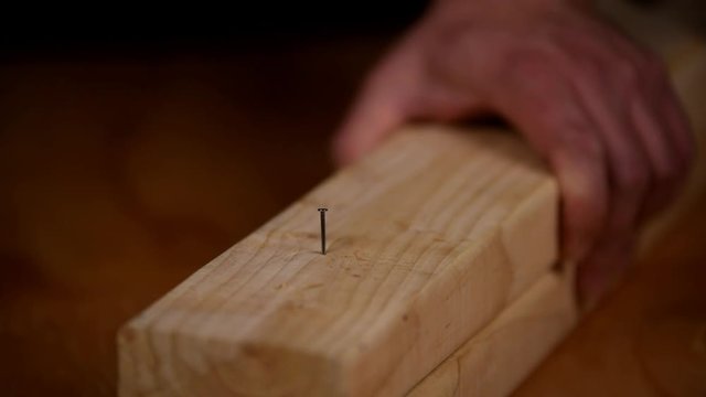 Hammering a nail into fresh lumber