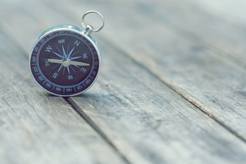 Compass on old wooden table background, journey concept, vintage tone