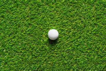 Golf ball on green grass texture of golf course for background.