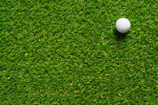 Golf ball on green grass texture of golf course for background.