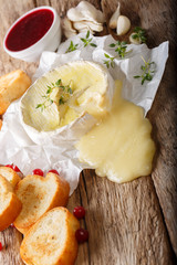 French cuisine: baked camembert cheese with toast and cranberry sauce close-up. vertical