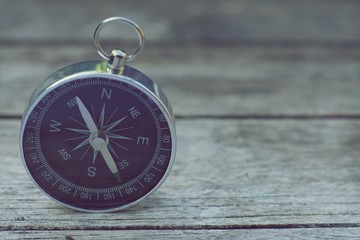 Compass on old wooden table background, journey concept, vintage tone