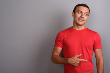 Man wearing red shirt against gray background